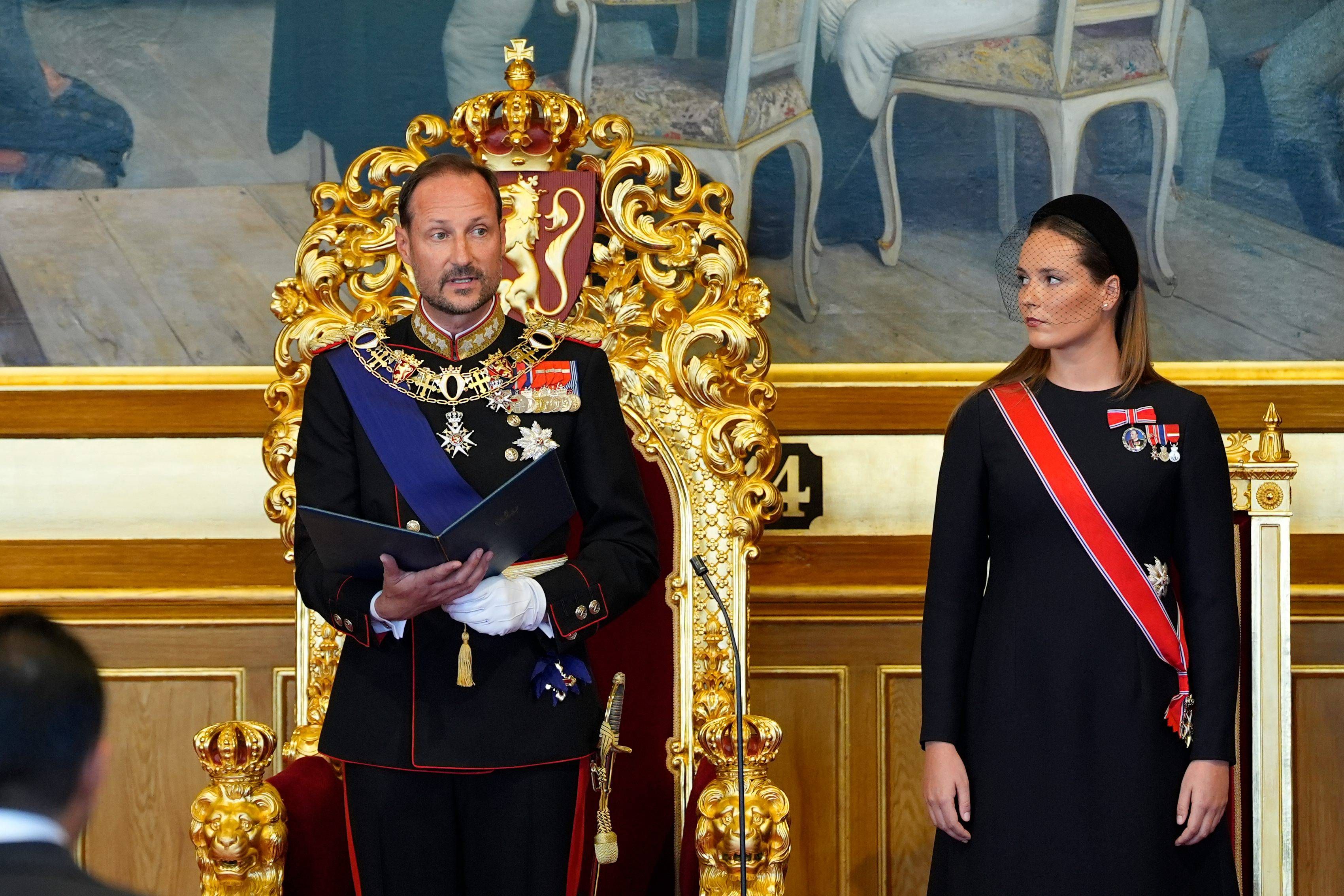 Haakon VIII de Noruega durante su lectura del juramento junto a la princesa heredera Ingrid