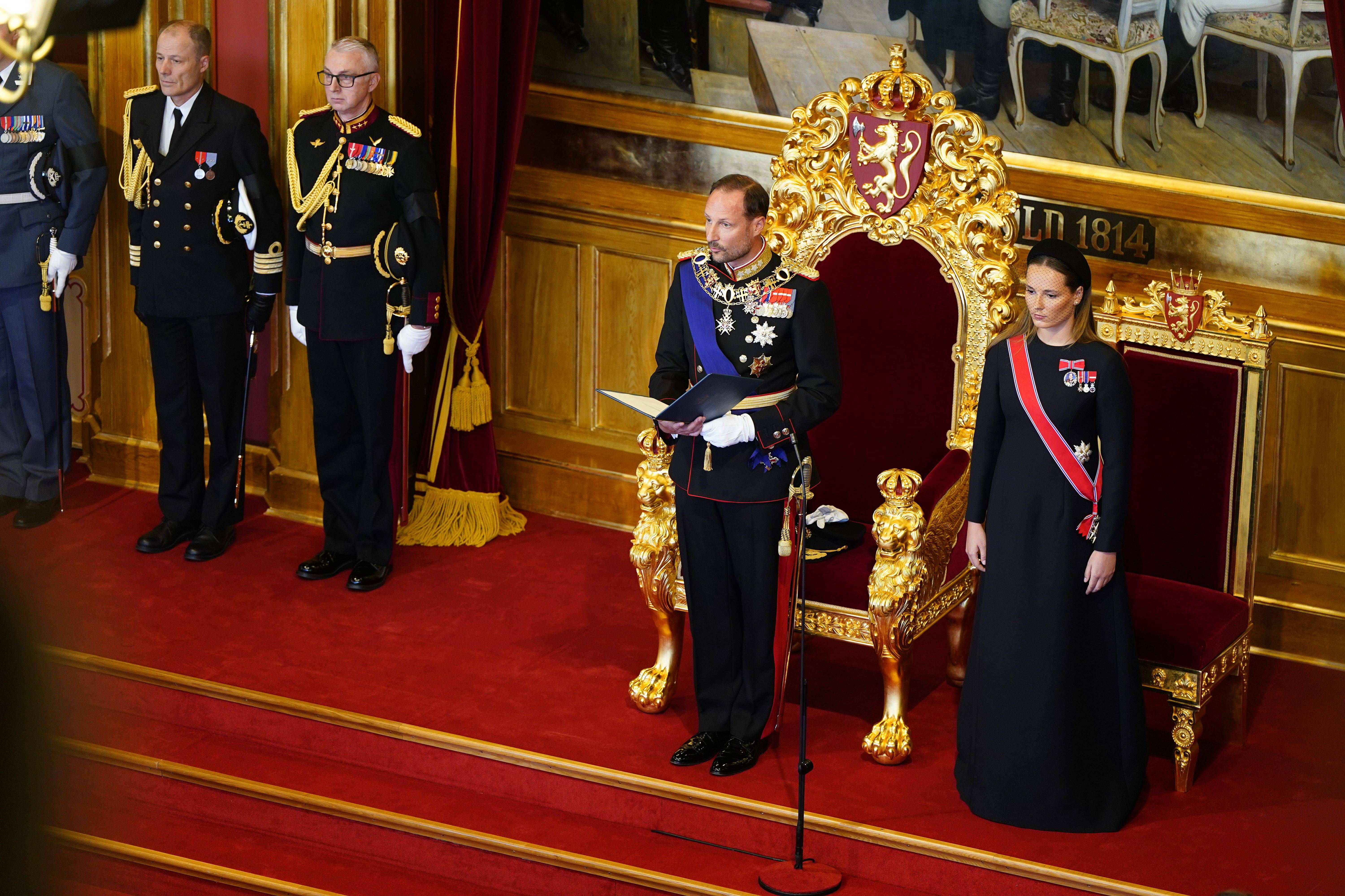Haakon VIII de Noruega durante su lectura del juramento junto a la princesa heredera Ingrid