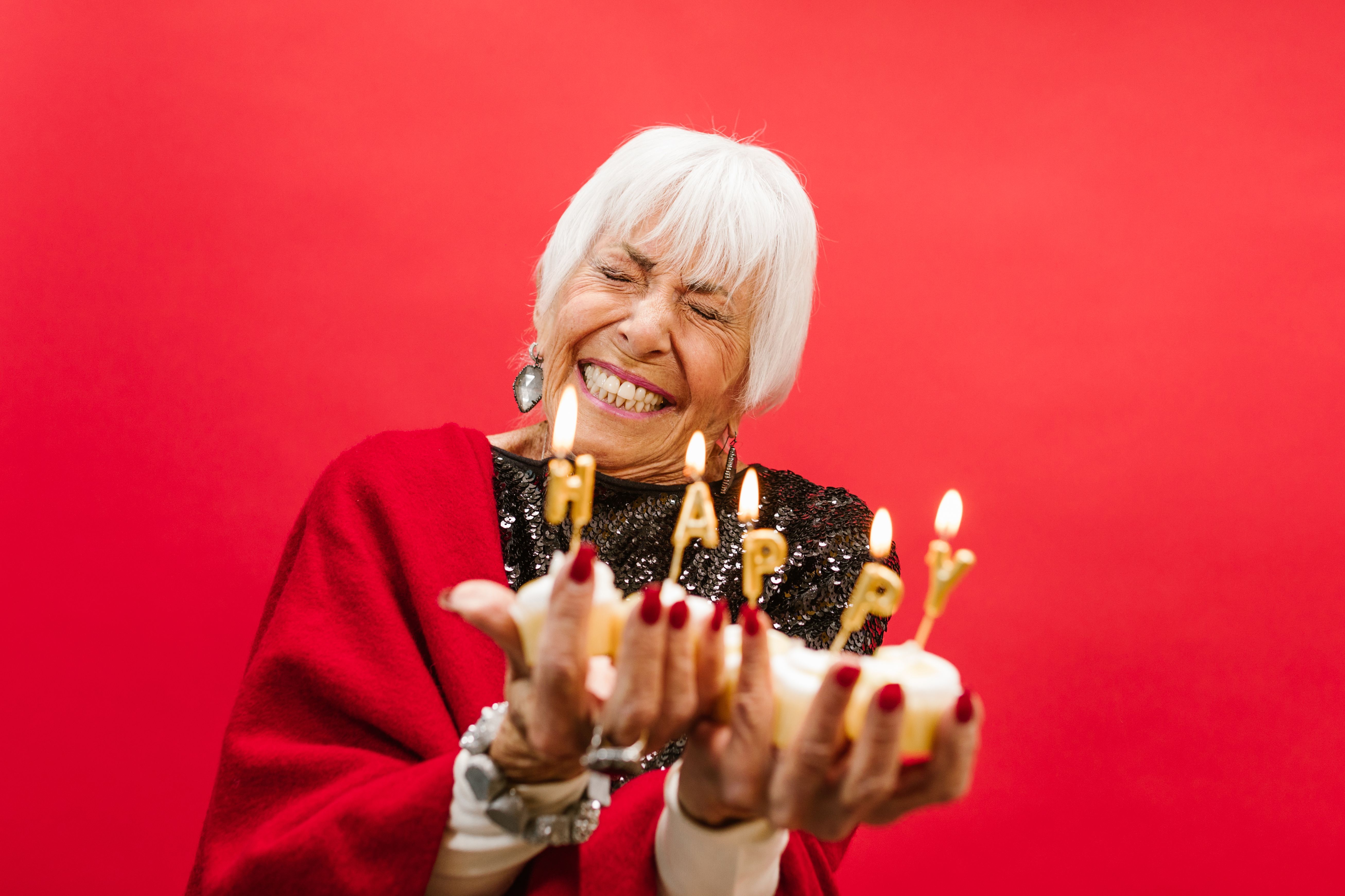 Mujer sosteniendo pasteles y velas