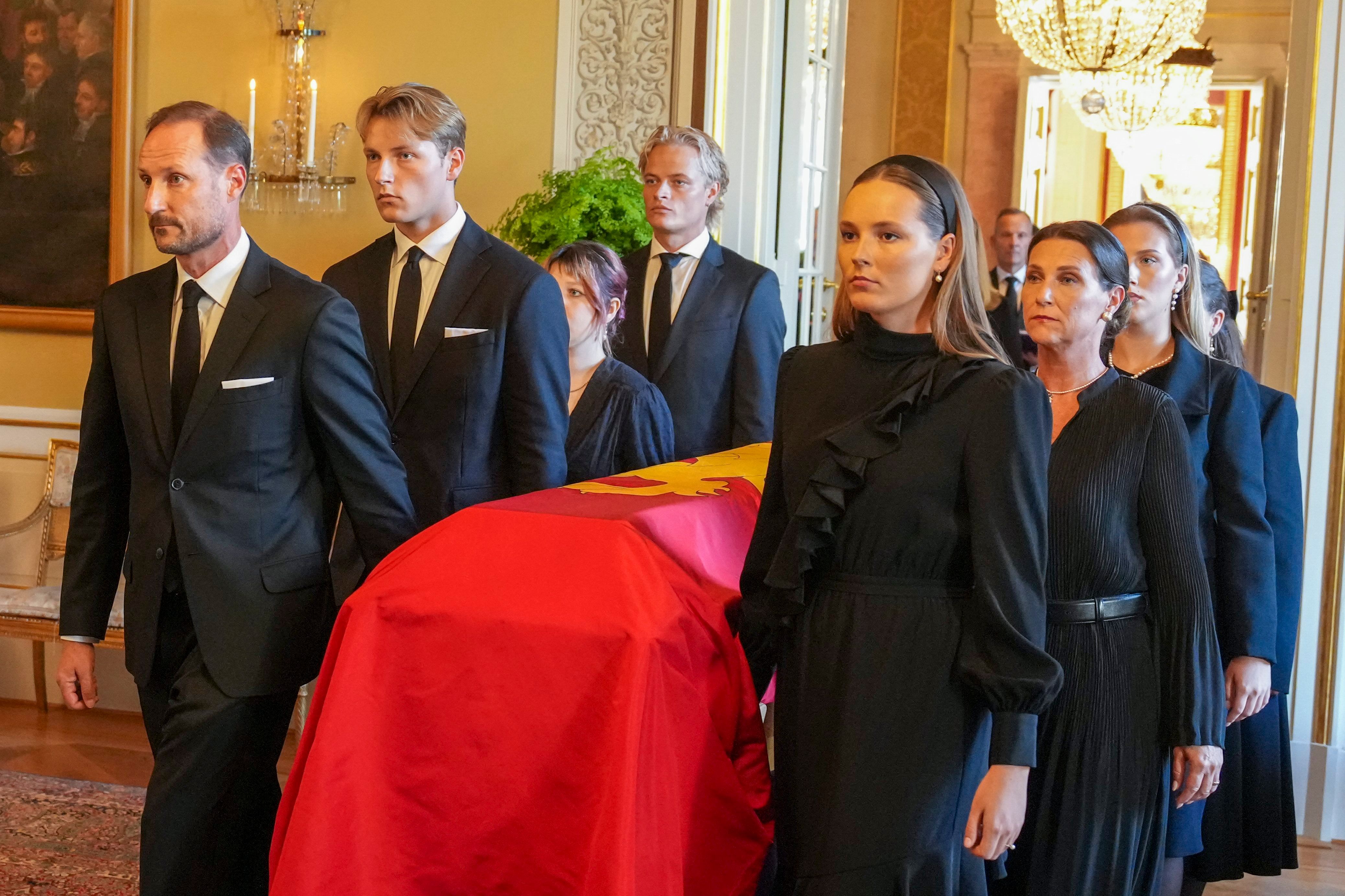 La familia real noruega, con Marius Borg al fondo, trasladando el féretro de Harald desde el Salón Rojo a la capilla