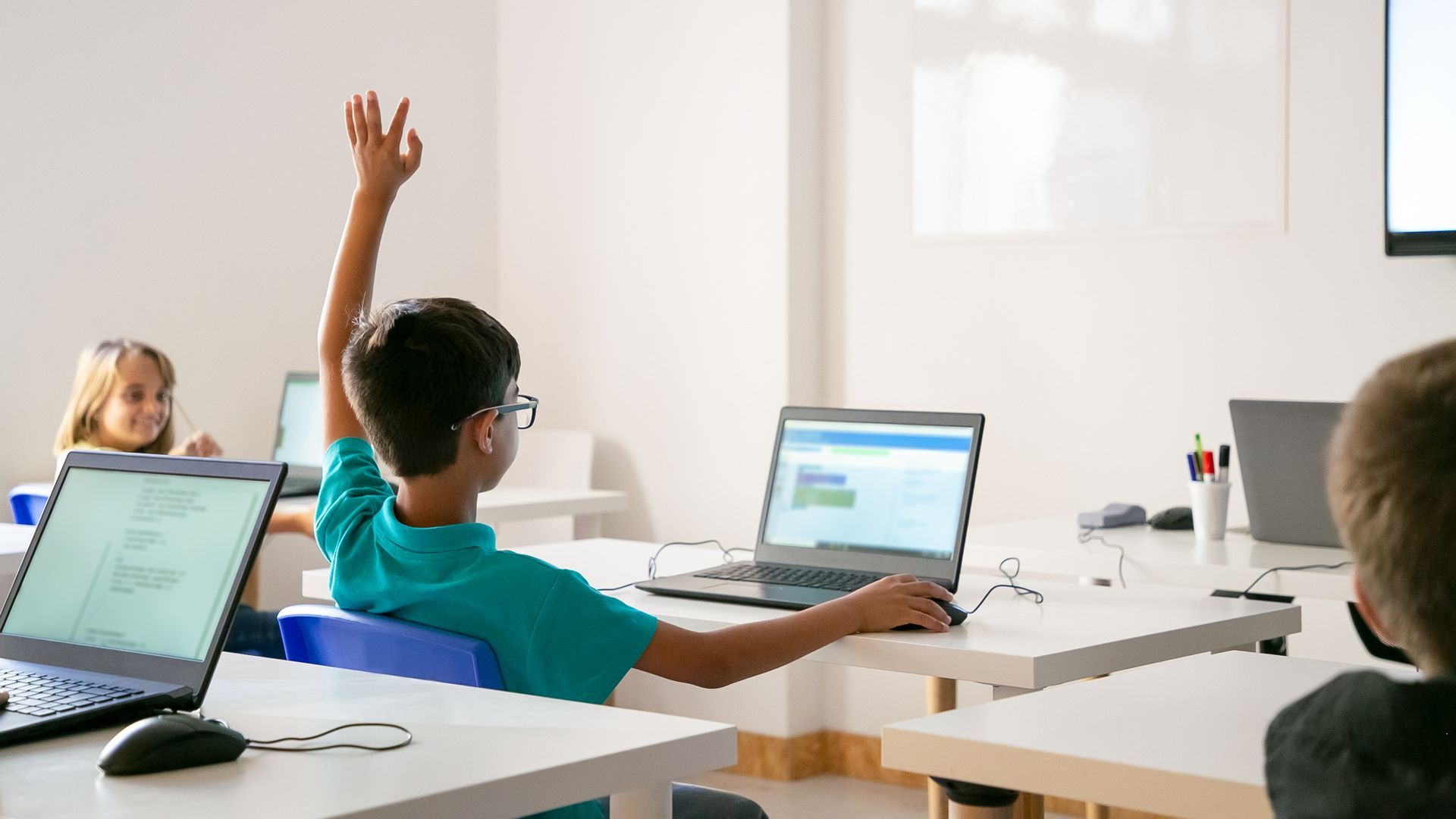 Un niño con un ordenador en clase Un niño con un ordenador en clase