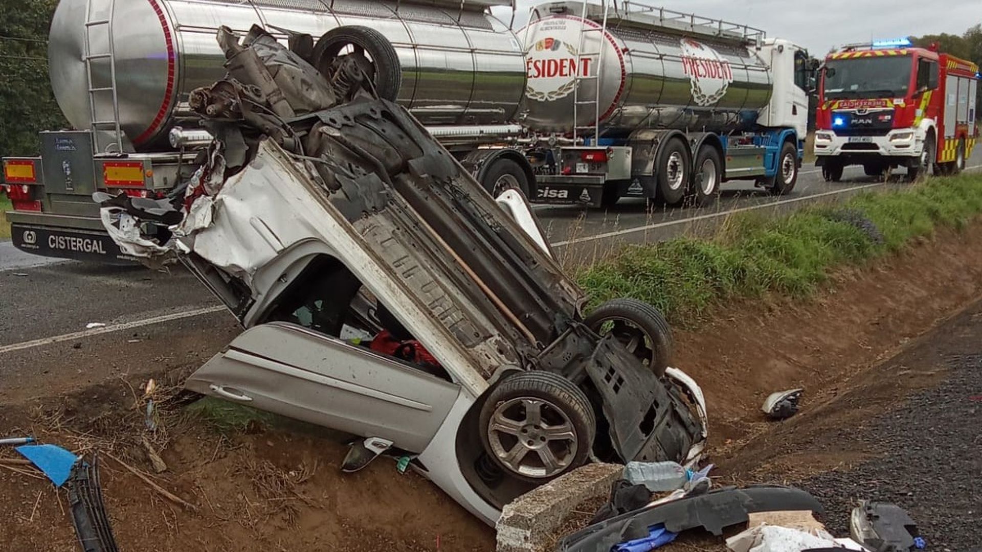 Coche volcado sobre una cuneta tras colisionar con el camión cisterna