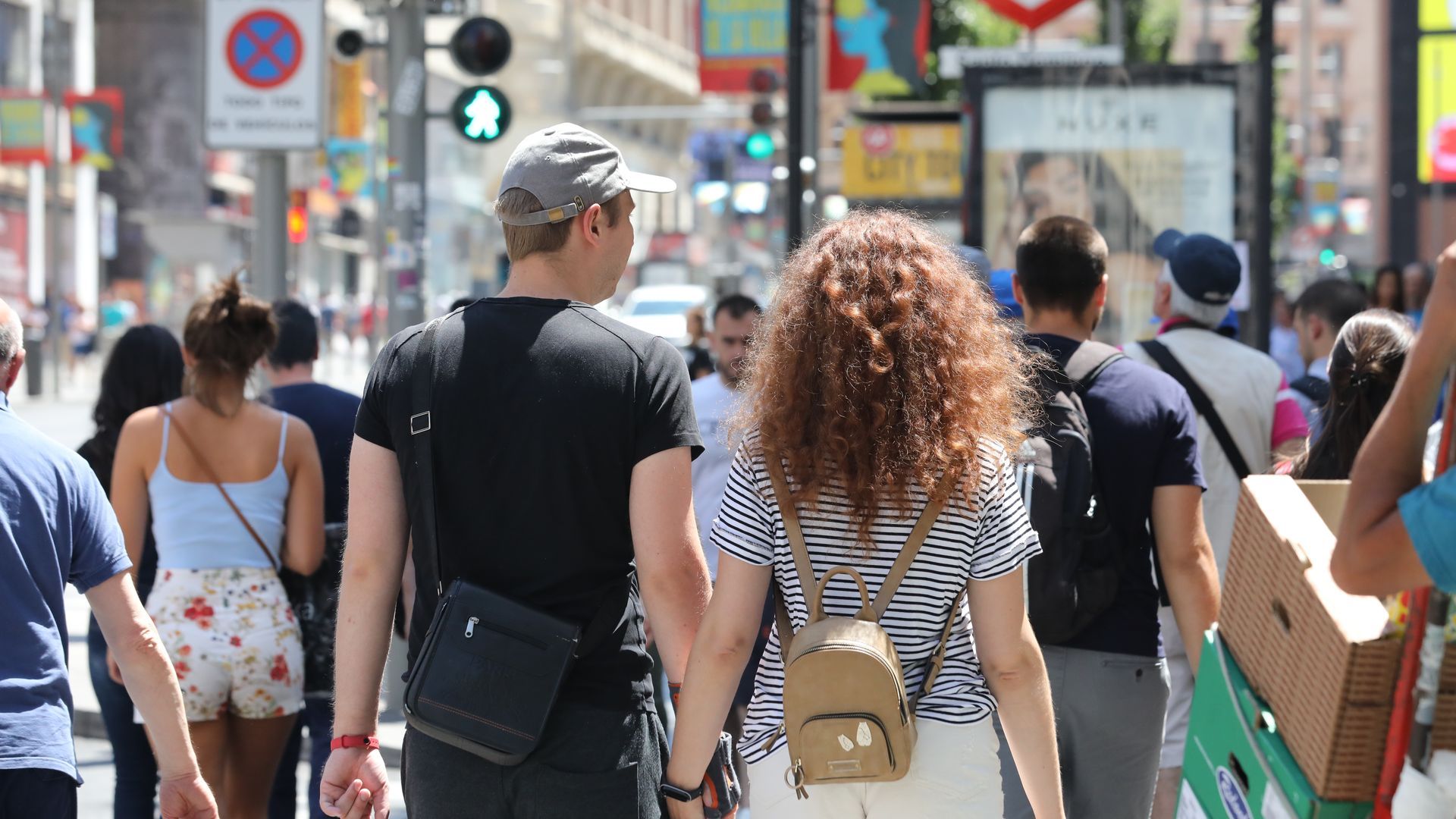 Una pareja cruza de la mano un paso de peatones de la Gran Vía de Madrid. Una pareja cruza de la mano un paso de peatones de la Gran Vía de Madrid.