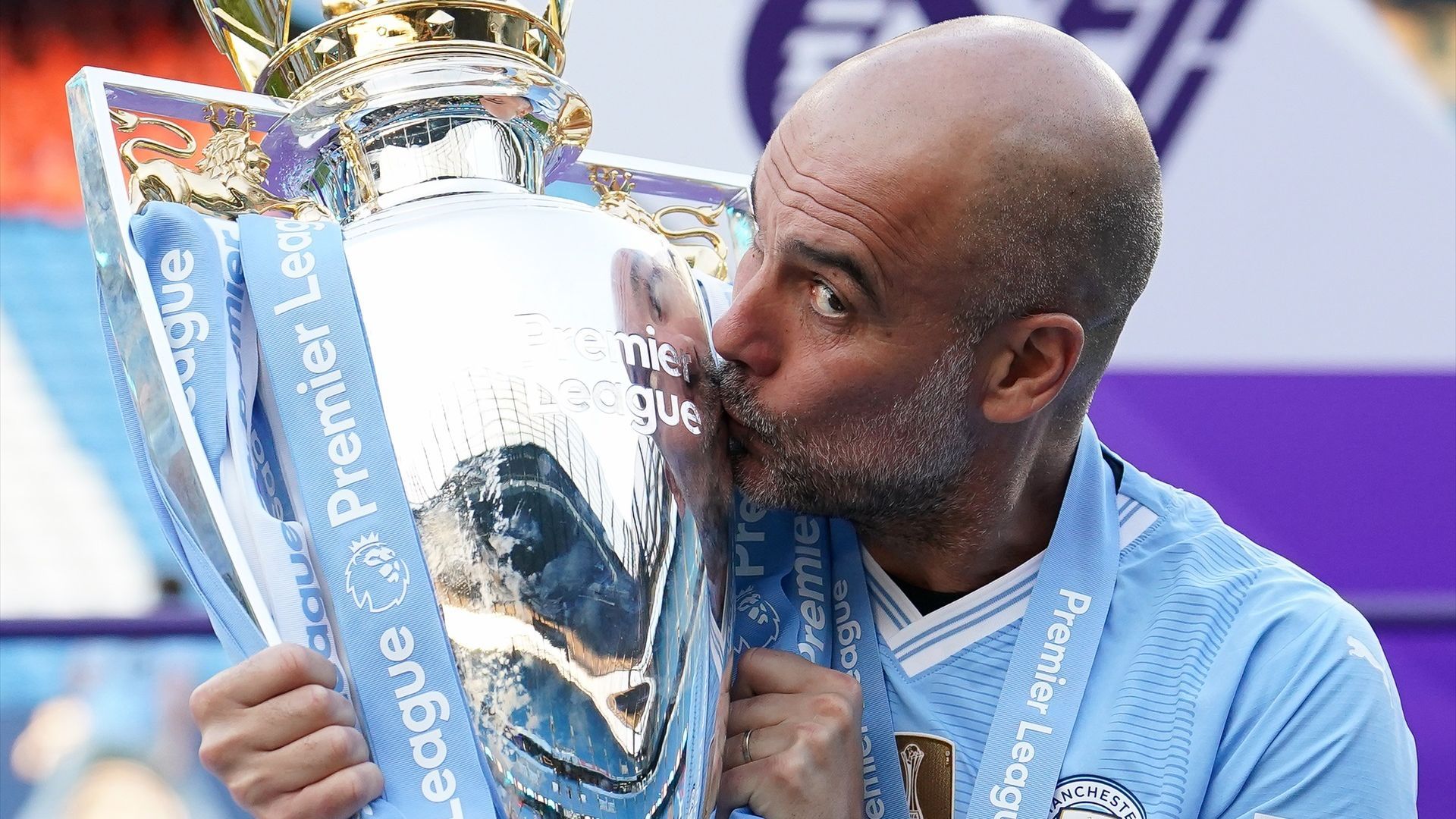 Pep Guardiola besando el trofeo de la Premier League conquistada por el Manchester City en 2024