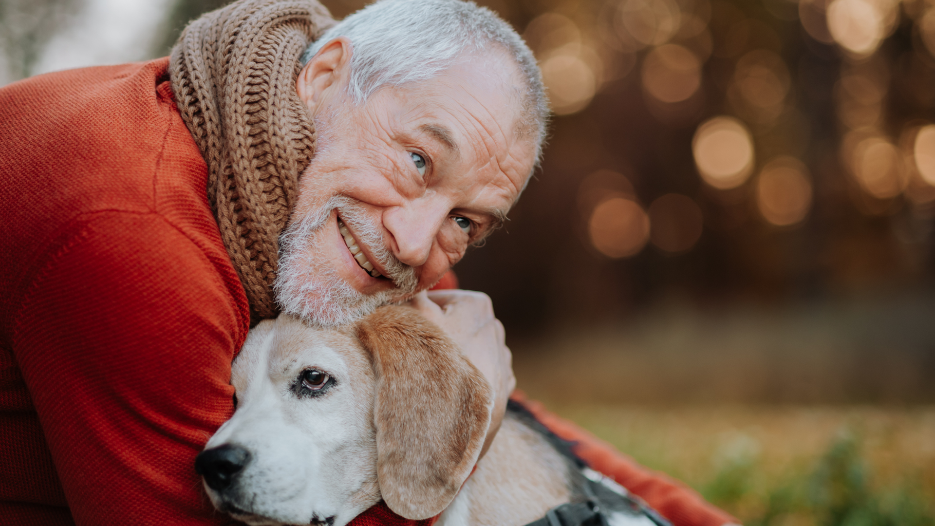 Un hombre, sonriente, abraza a su perro Un hombre, sonriente, abraza a su perro
