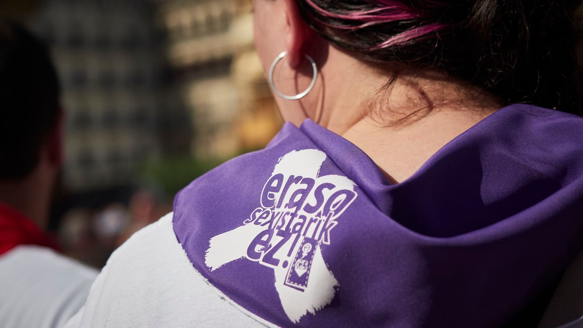 Una mujer con un pañuelo de color morado en el cuello durante una concentración contra una agresión sexual Una mujer con un pañuelo de color morado en el cuello durante una concentración contra una agresión sexual