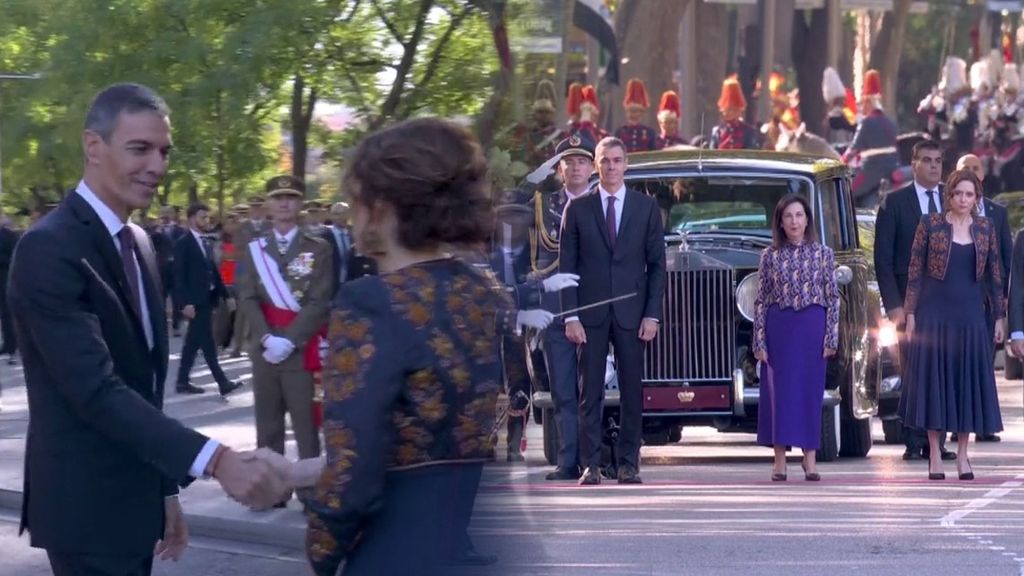 El saludo entre Pedro Sánchez e Isabel Díaz Ayuso antes del desfile y su distanciamiento durante el himno nacional con un hueco vacío y la ministra Robles en medio
