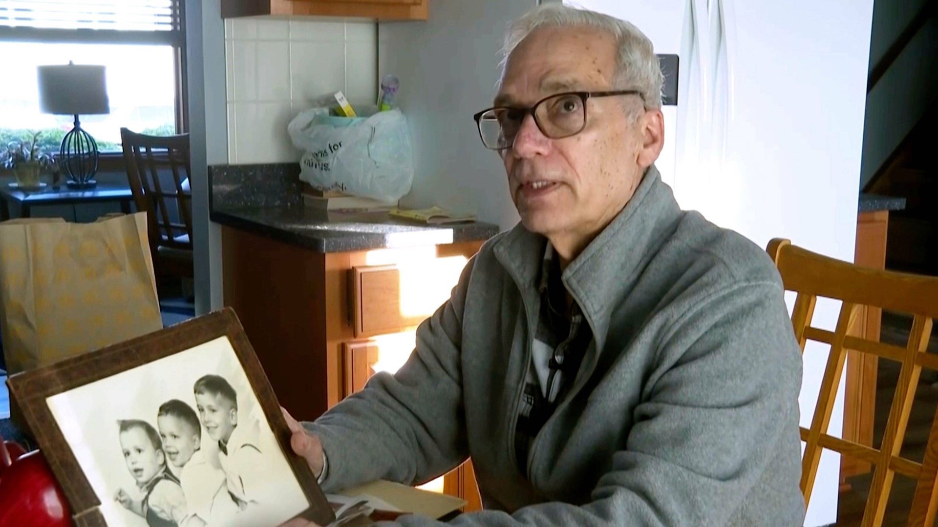 John Prevost, hermano mediano del papa León XIV, sostiene un retrato de los tres hermanos Prevost de 1958 —el papa León (de 3 años, a la izquierda), John (de 4) y Louis (de 7)— en su casa de New Lenox, Illinois, el 8 de mayo de 2025