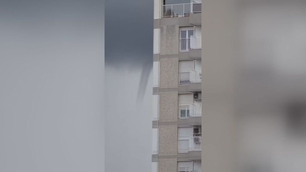 Una tuba se descuelga y deja ver sobre el cielo nuboso de Alicante durante una tormenta