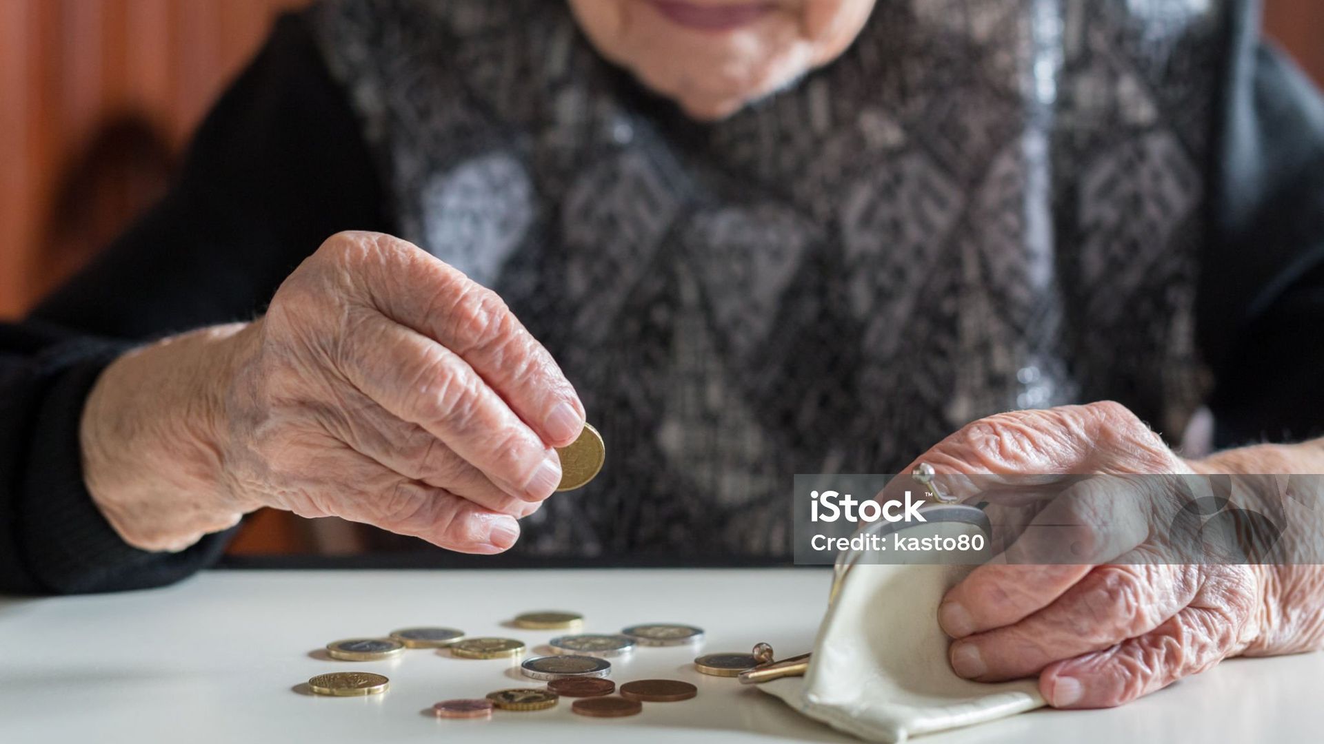 Una mujer mayor contando dinero en casa