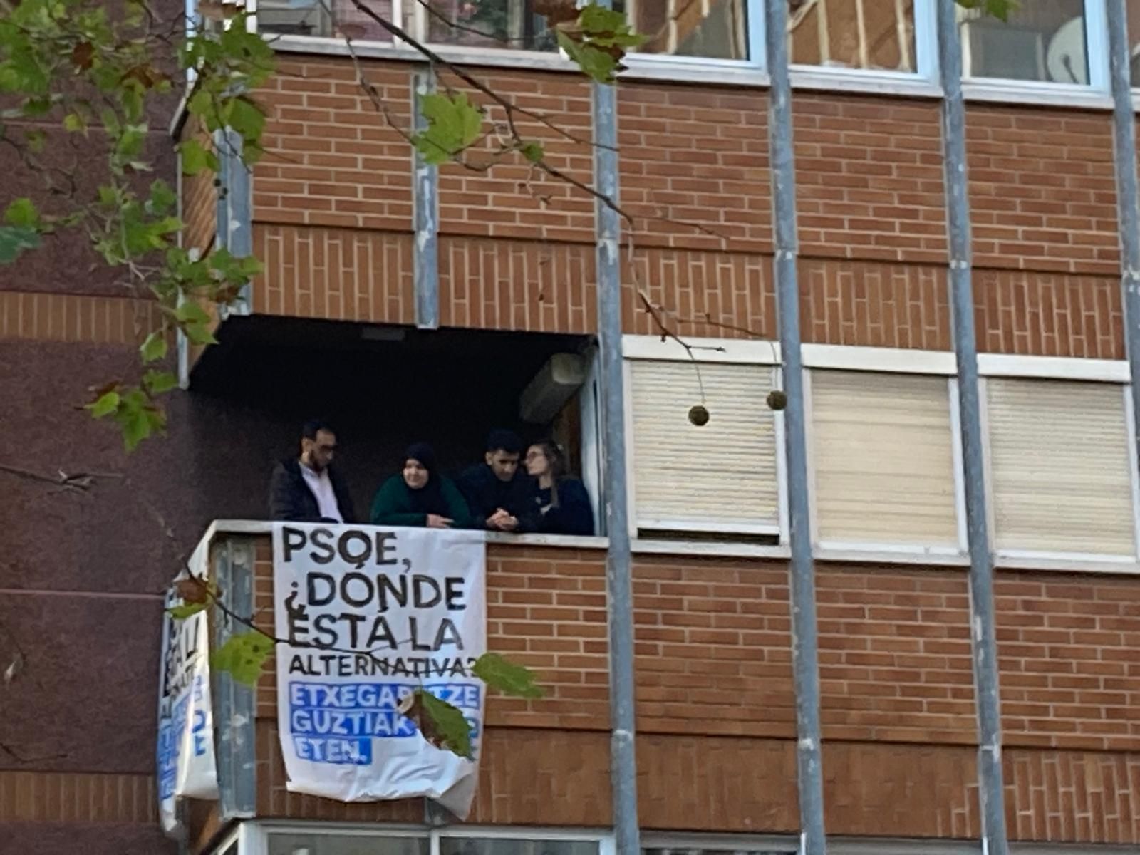 Un cartel cuelga desde la ventana de la vivienda